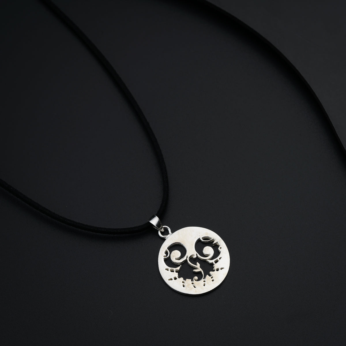 a black and white photo of a necklace on a black background