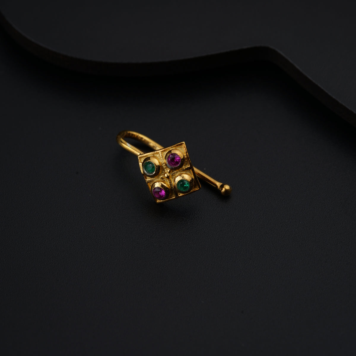 a close up of a pair of earrings on a black surface