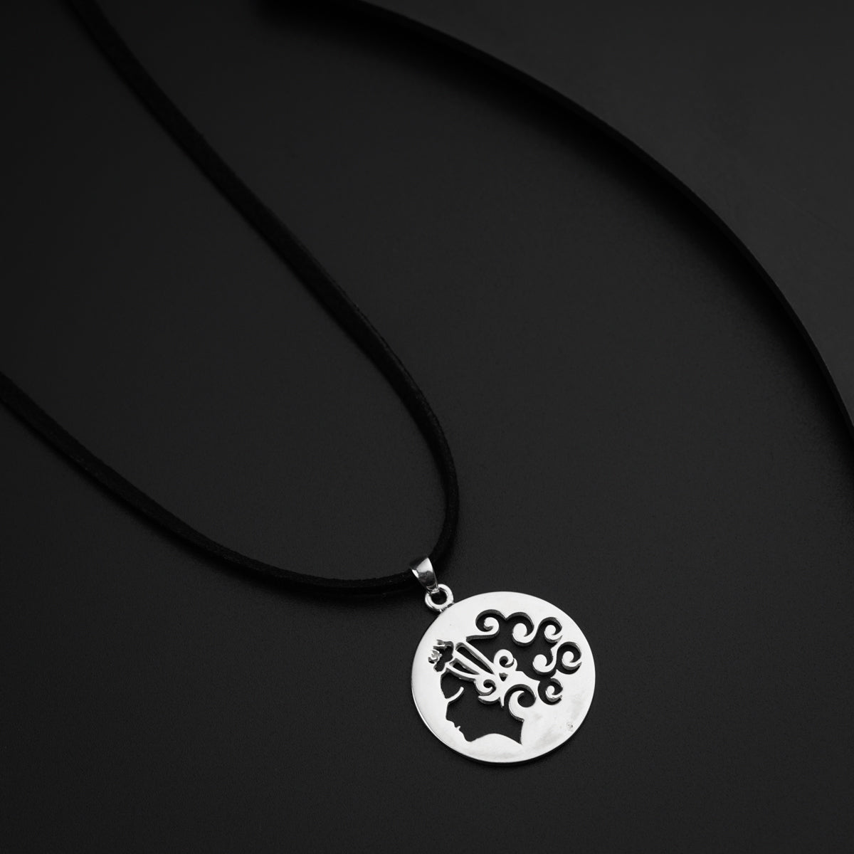 a black and white photo of a necklace on a black surface