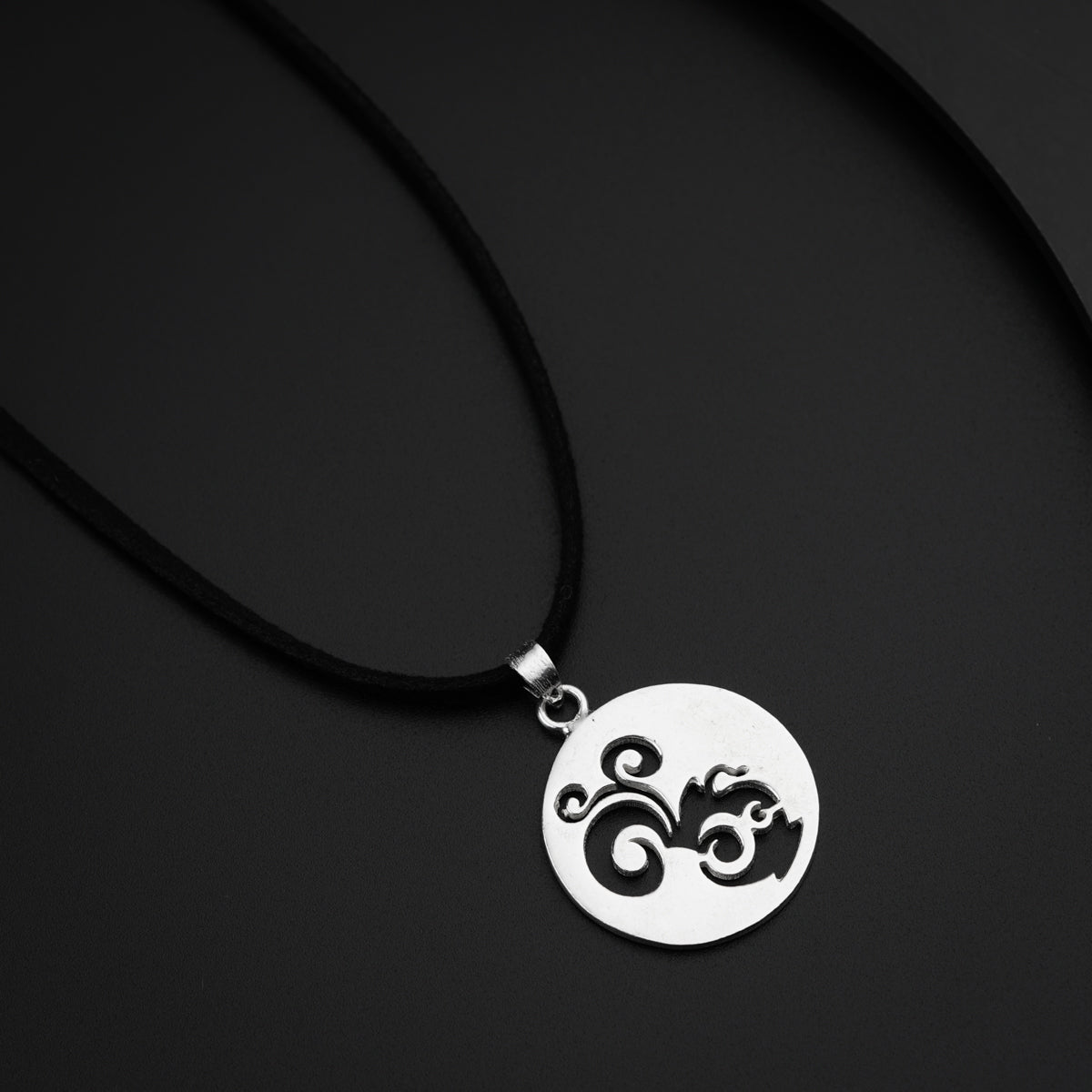 a black and white photo of a necklace on a black surface