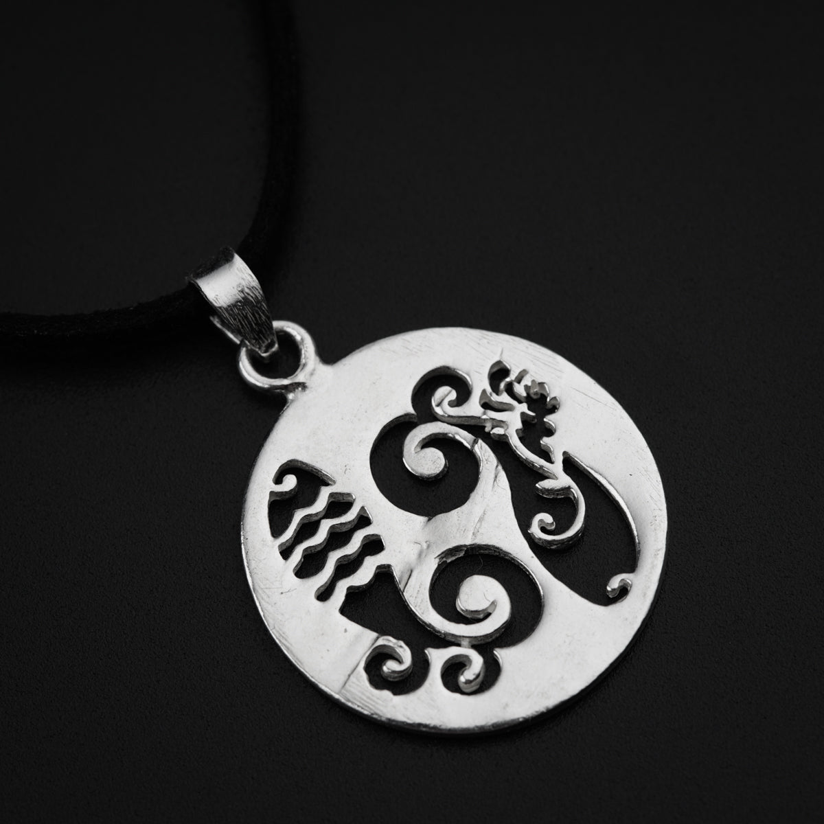 a silver pendant with a bird on it