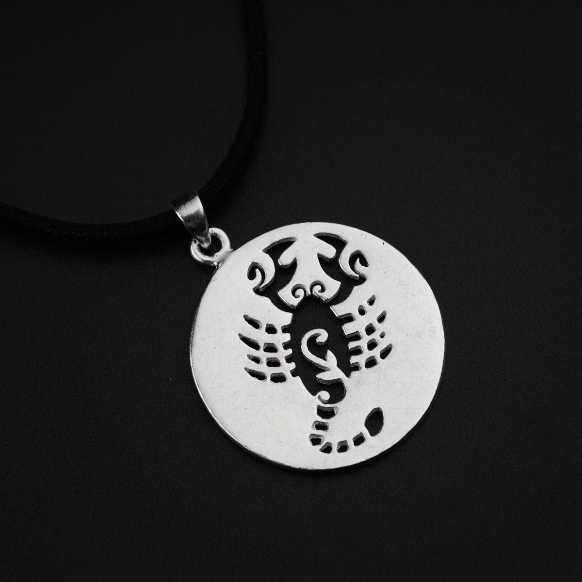 a silver pendant with a scorpion on it