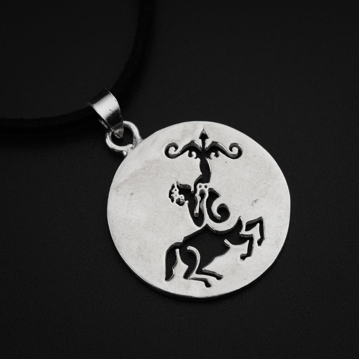 a silver pendant with a horse on it