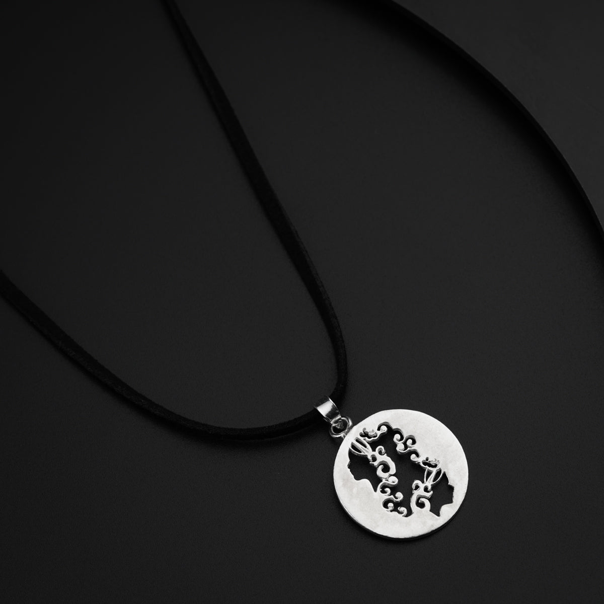 a black and white photo of a pendant on a black background
