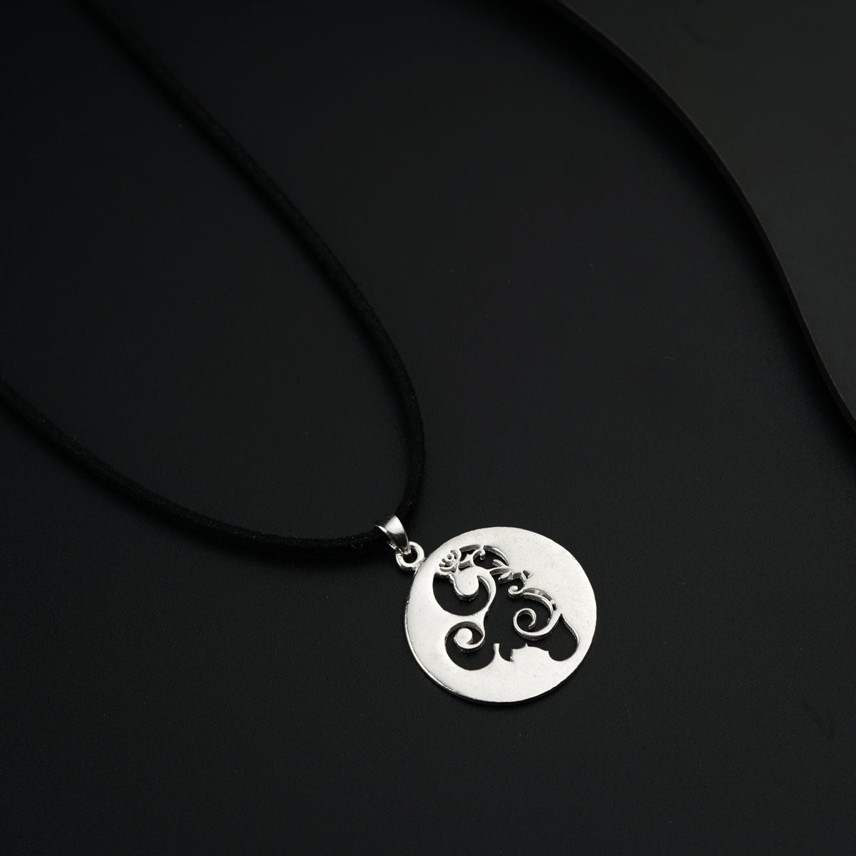 a black and white photo of a necklace with an elephant on it