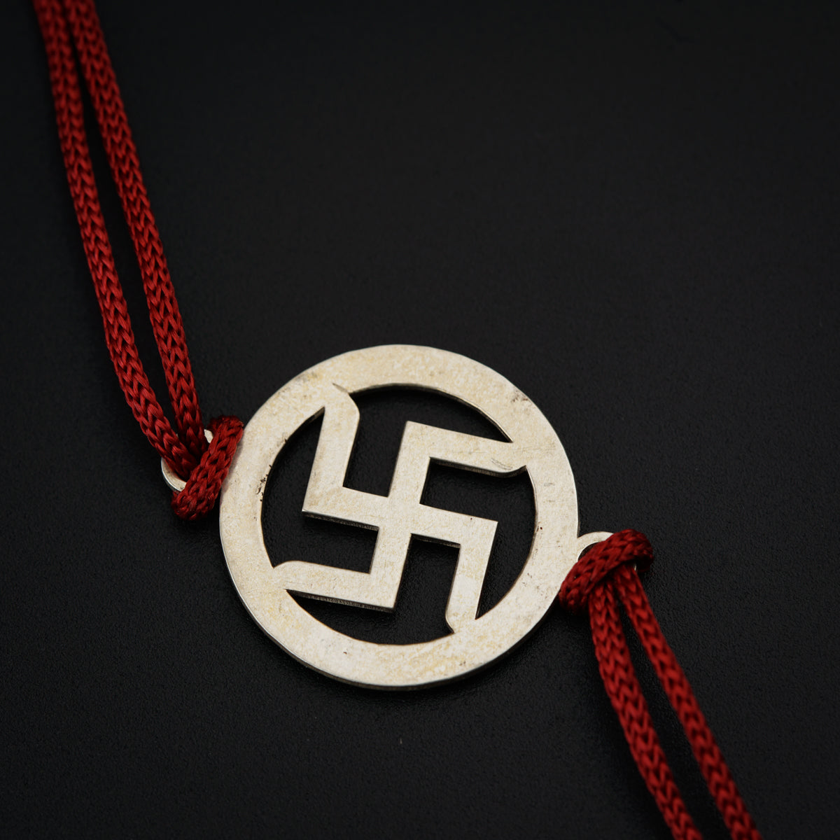 a white and red necklace on a black surface