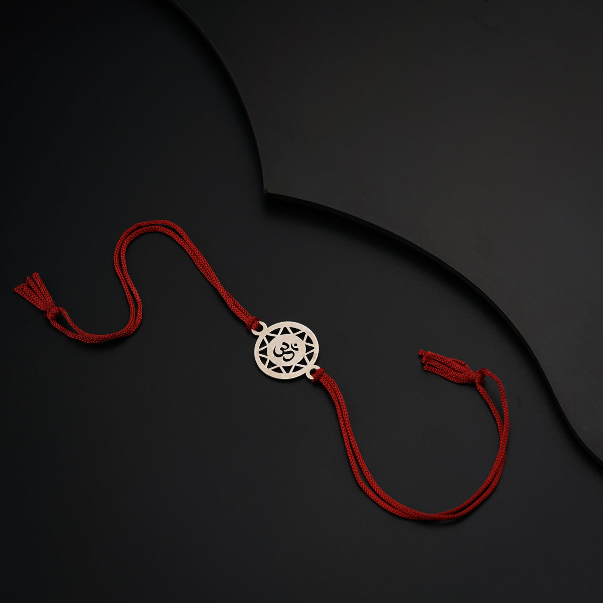 a red string with a silver medallion on it
