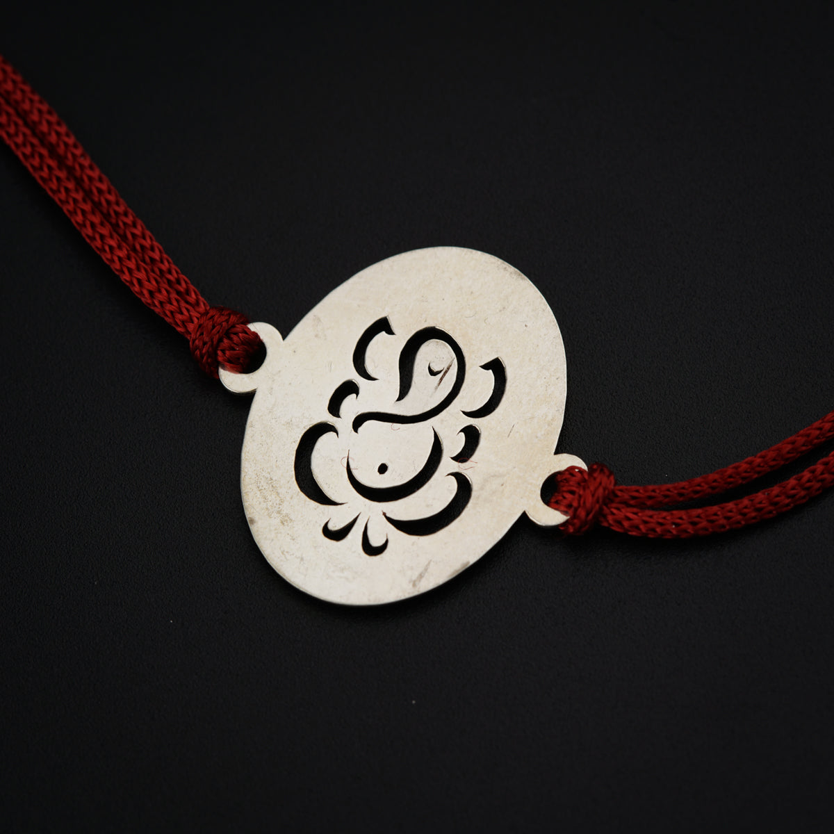 a white pendant with a black design on it
