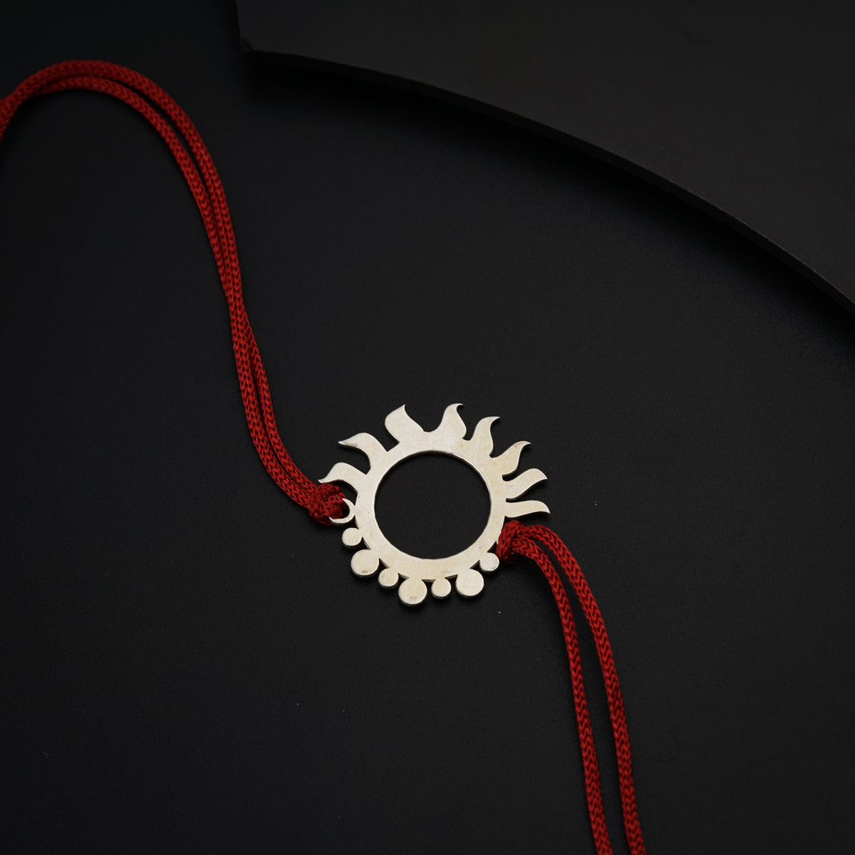 a red string with a circular pendant on it