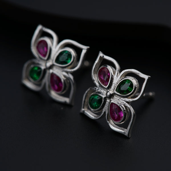 a pair of earrings with green and red stones