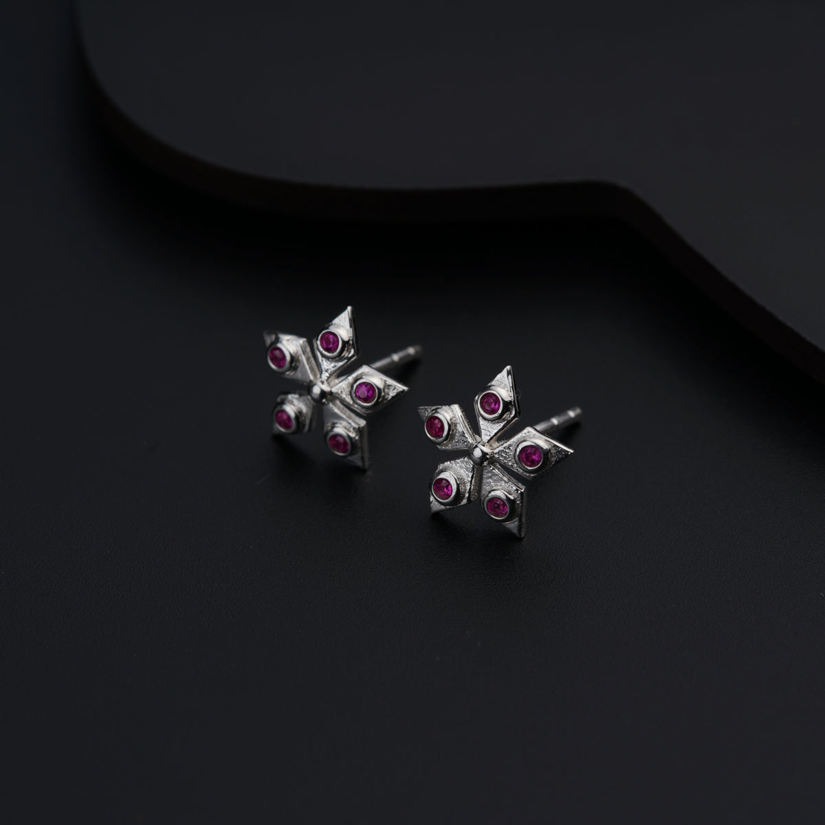 a pair of silver earrings with pink stones