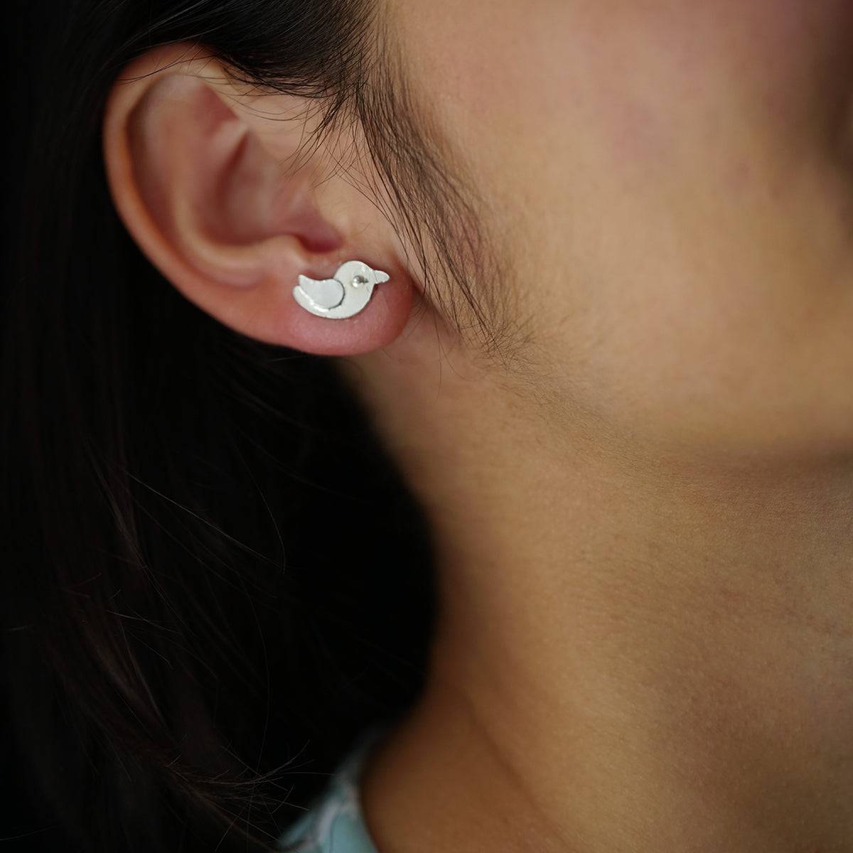 a close up of a person wearing a pair of earrings