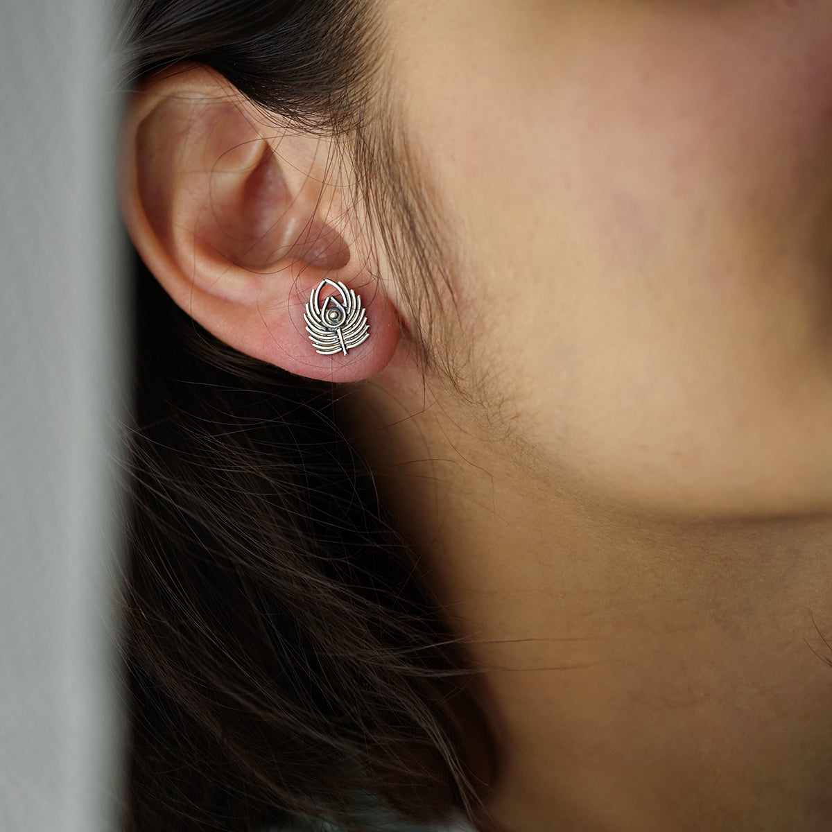 a close up of a person wearing a pair of earrings