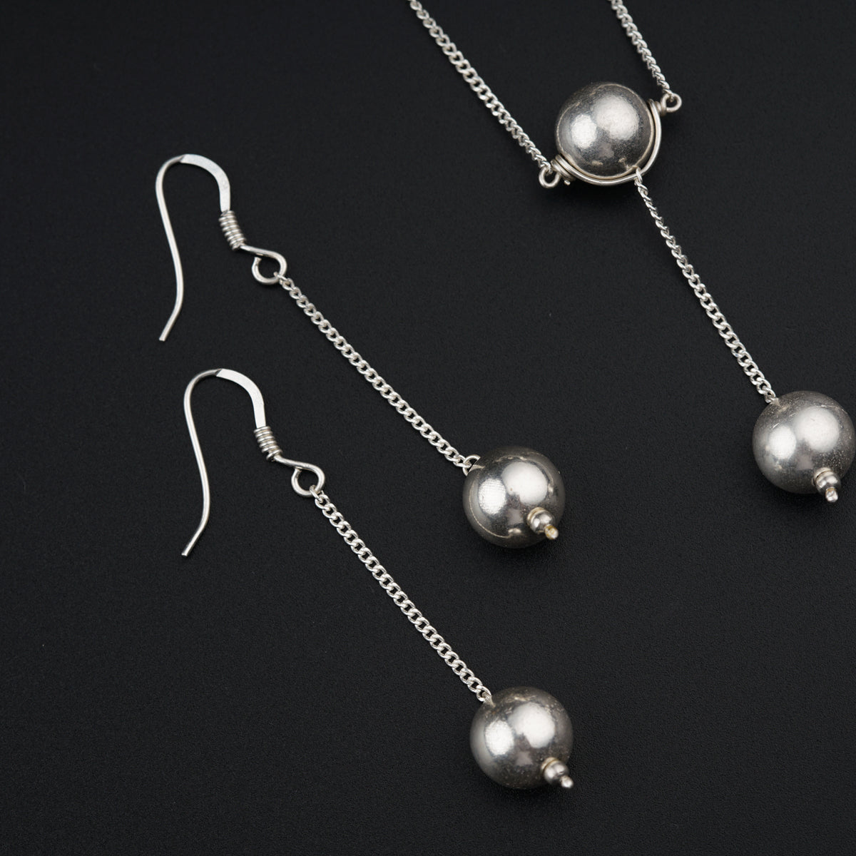 a pair of silver earrings on a black background