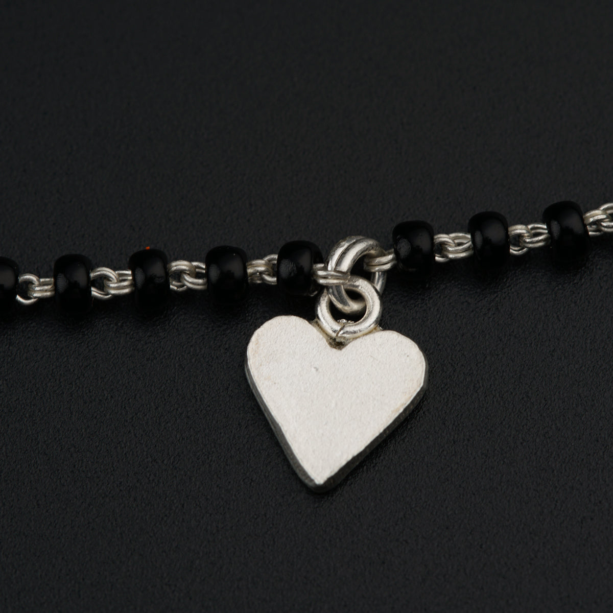 a black and silver bracelet with a heart charm
