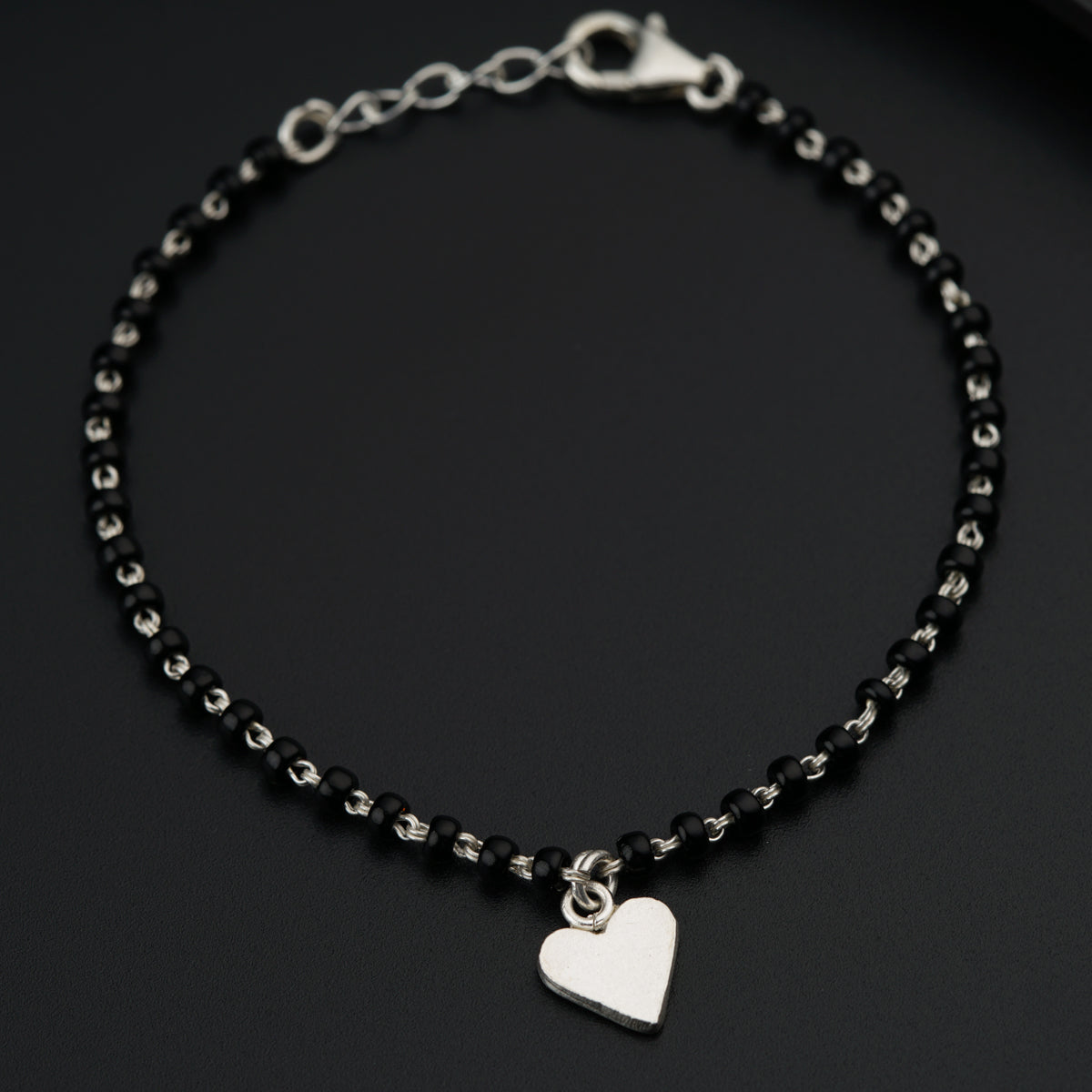 a black beaded bracelet with a heart charm