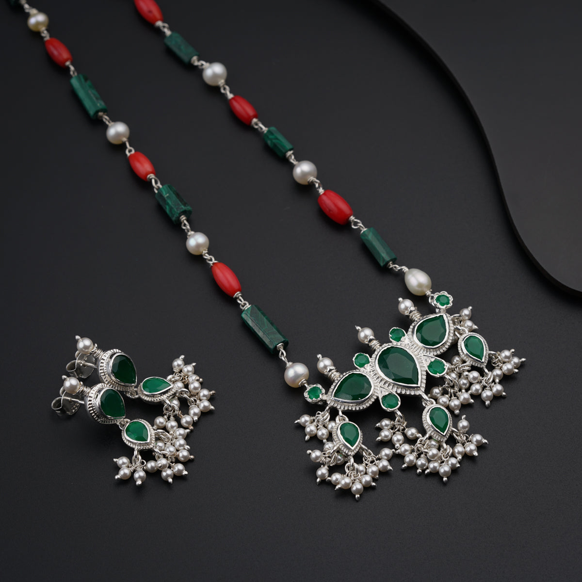 a long necklace with green and red beads