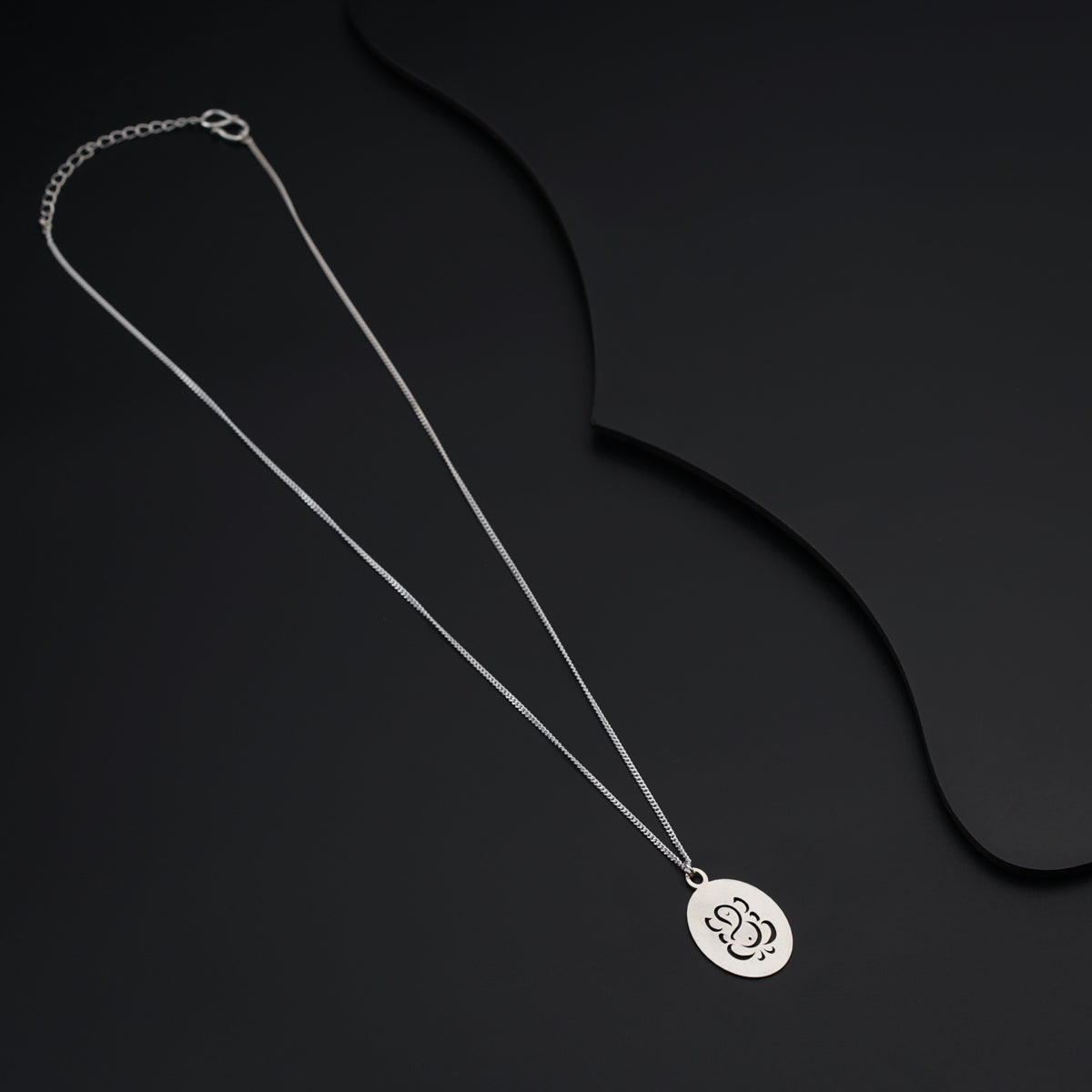 a silver necklace with a monogram on it