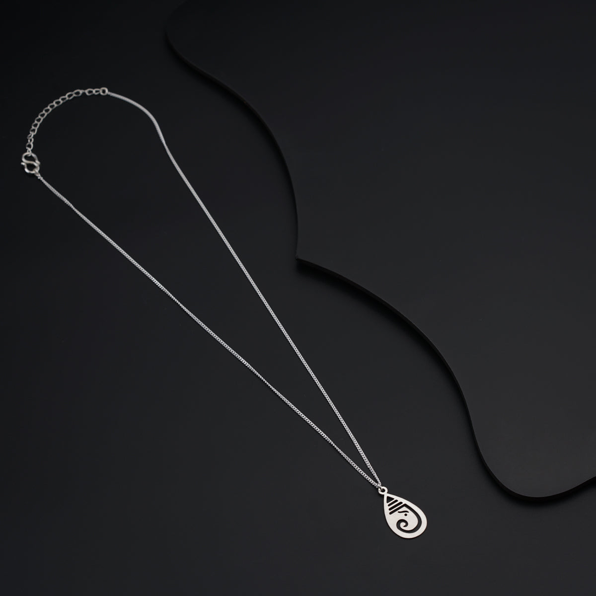 a necklace with a spiral design on a black background