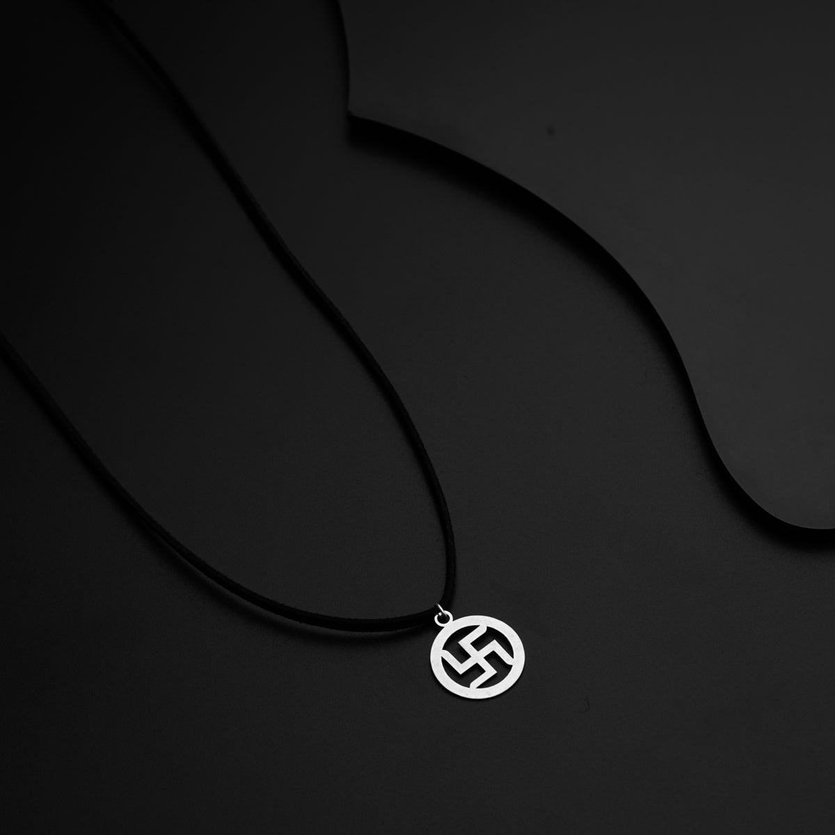 a black and white photo of a necklace on a black background