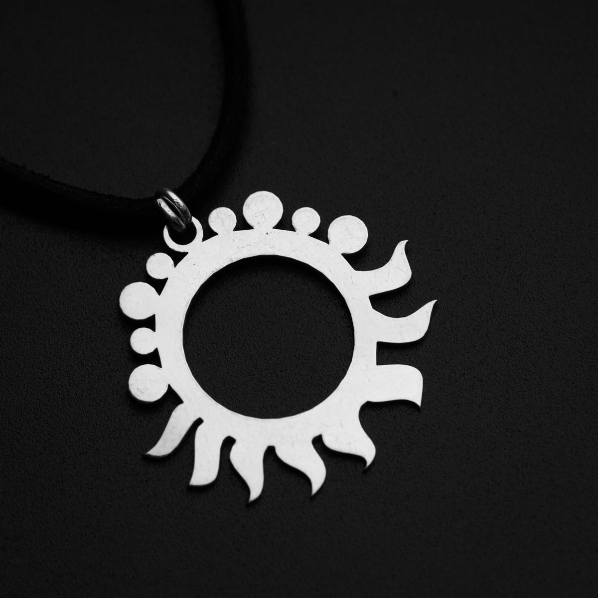 a necklace with a circular design on a black background