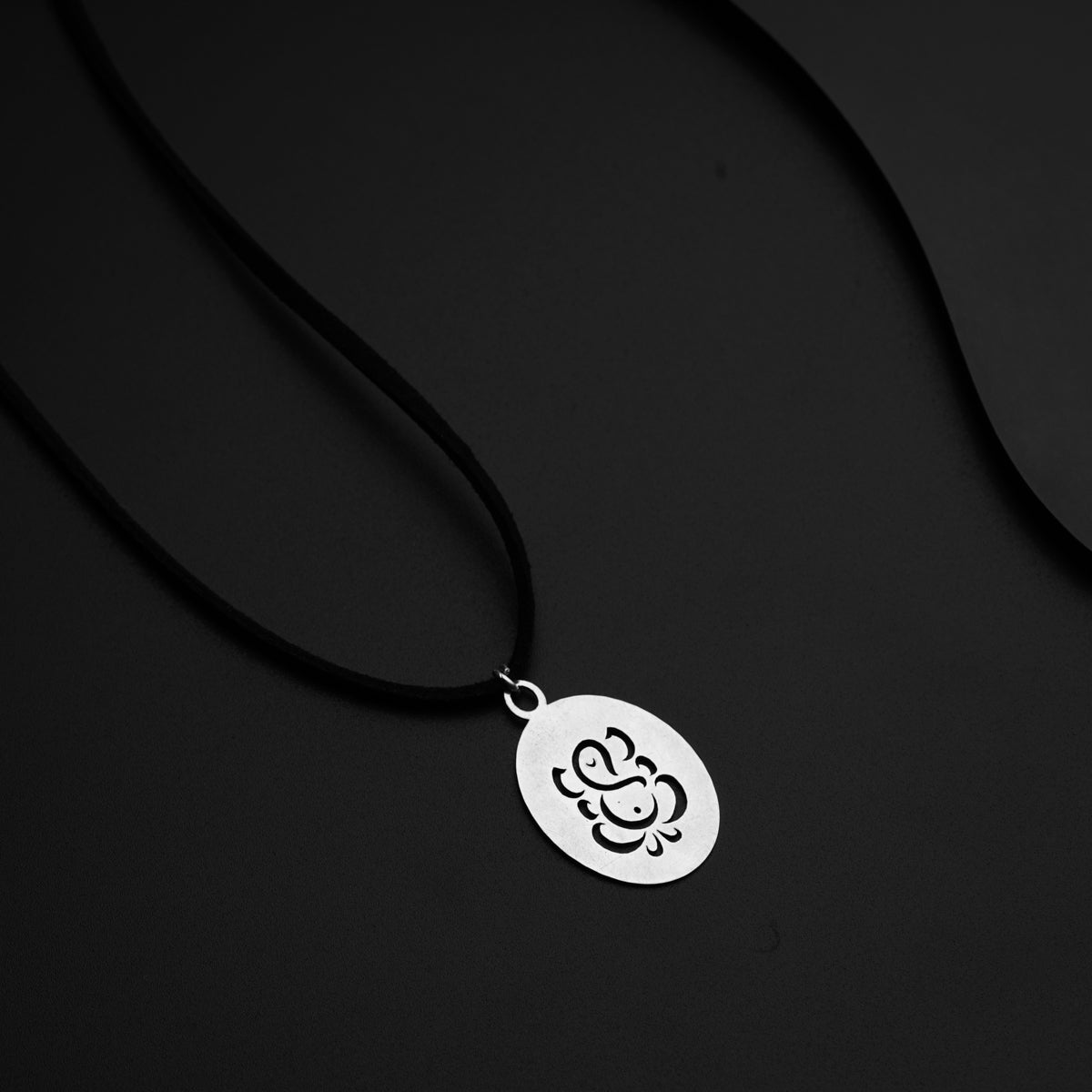 a necklace with a flower on a black background