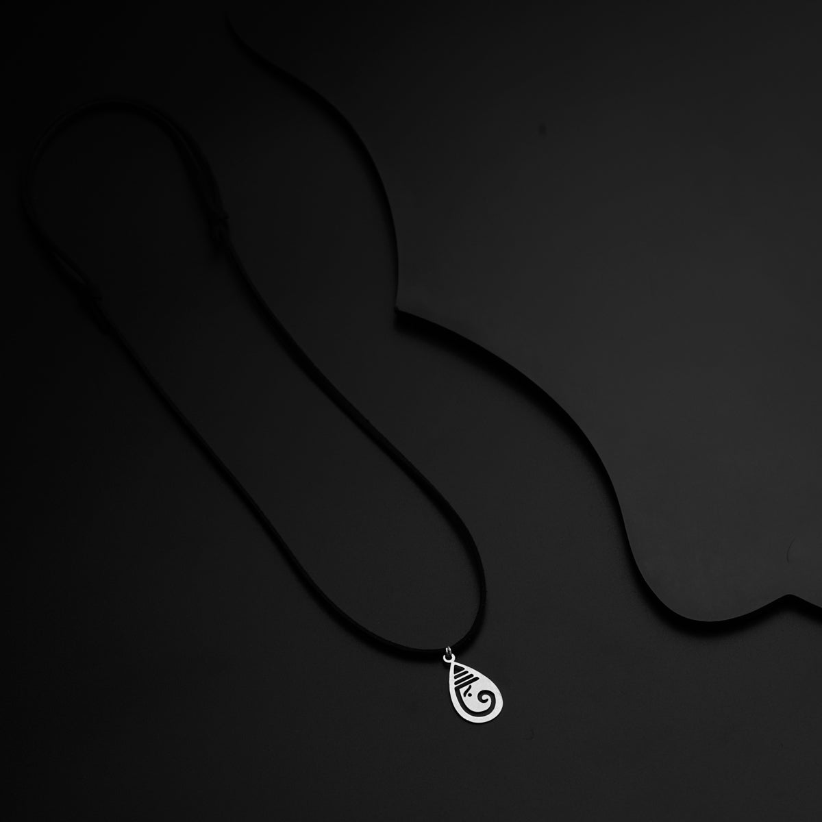 a black and white photo of a necklace