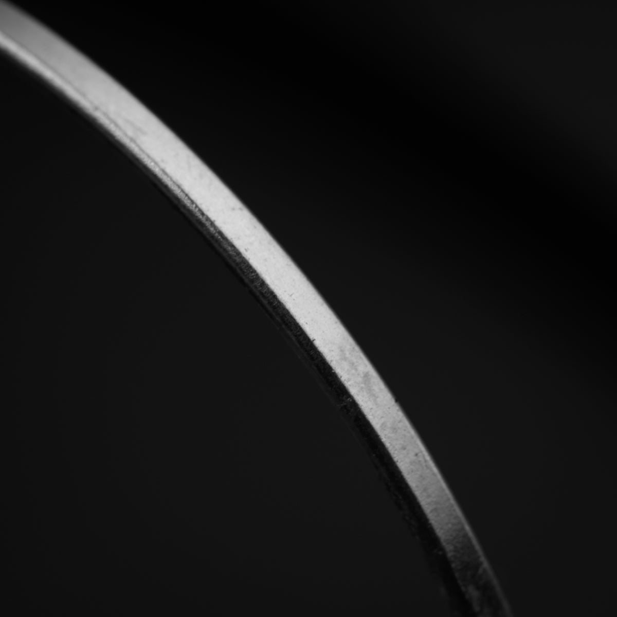 a black and white photo of a curved metal object
