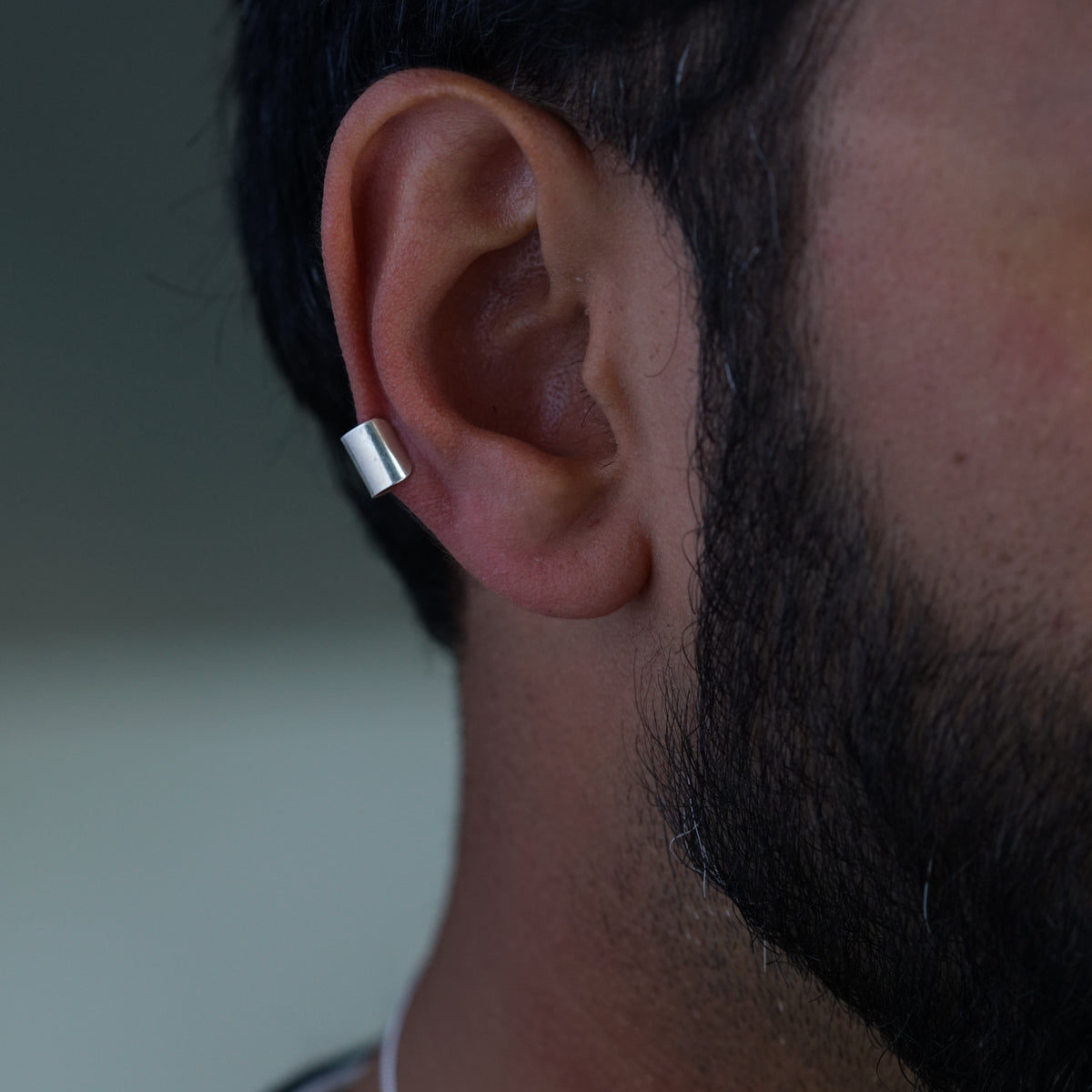 a close up of a man's ear with a ring on it