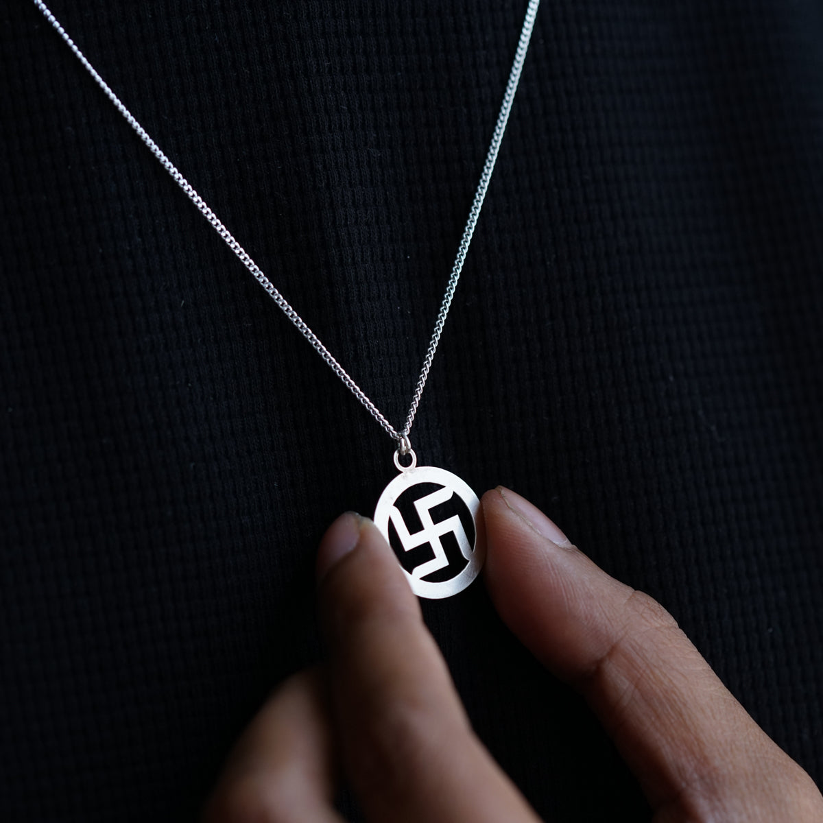 swastik symbol detailing on silver pendant