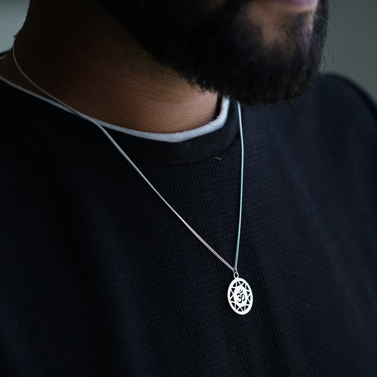 a close up of a man wearing a necklace