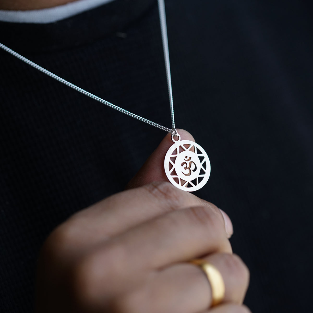 a person wearing a necklace with a symbol on it