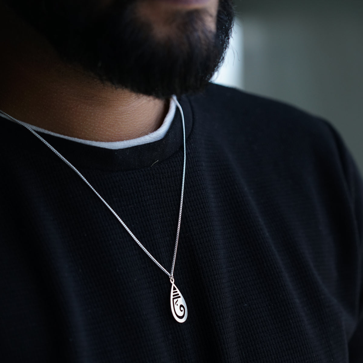 a close up of a man wearing a necklace