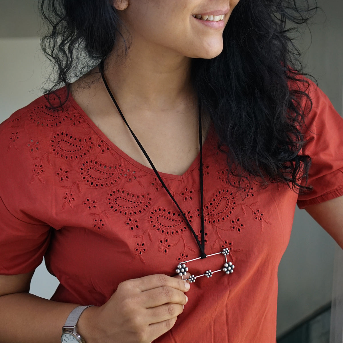 a woman wearing a red shirt and a necklace