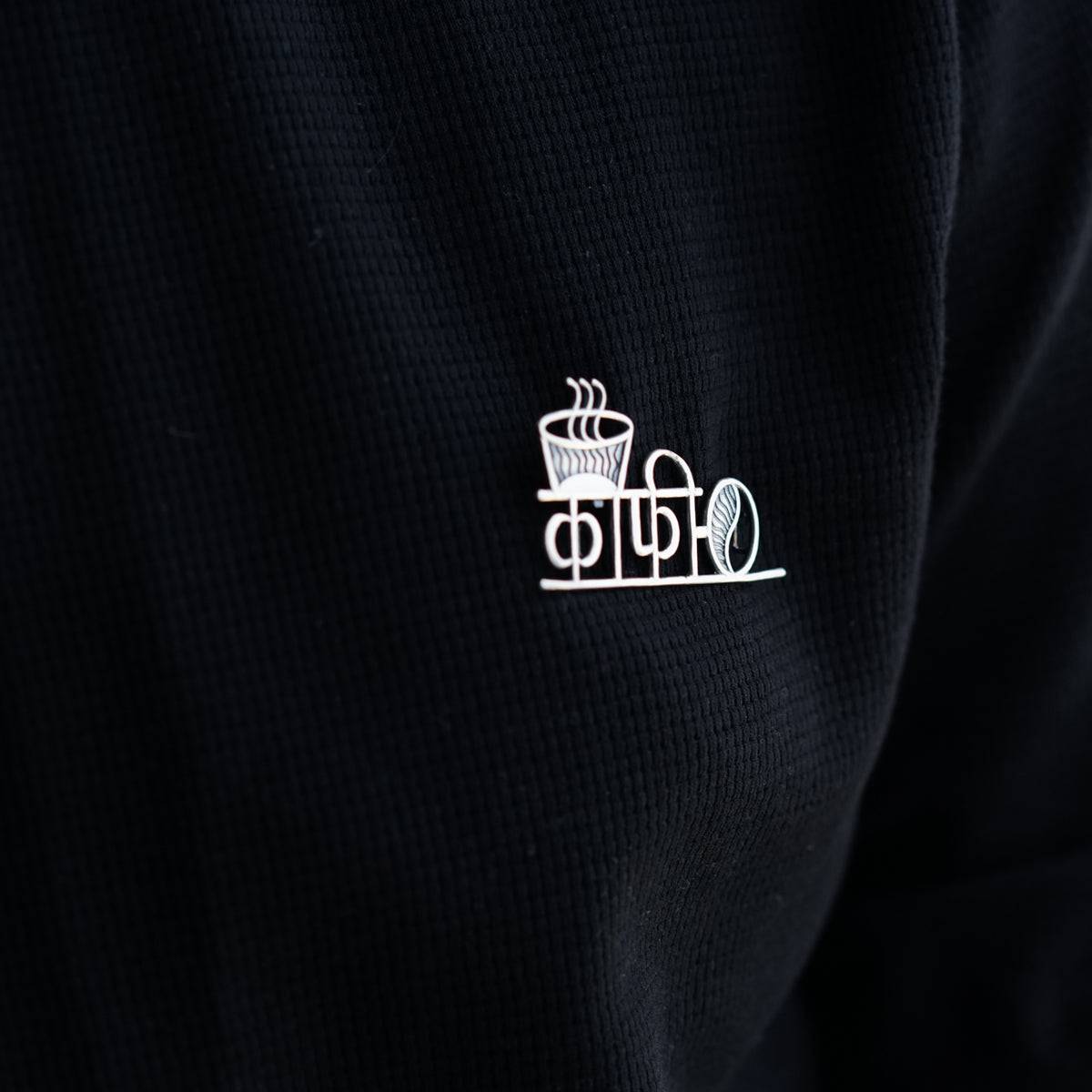 a person wearing a black shirt with a cup of coffee on it