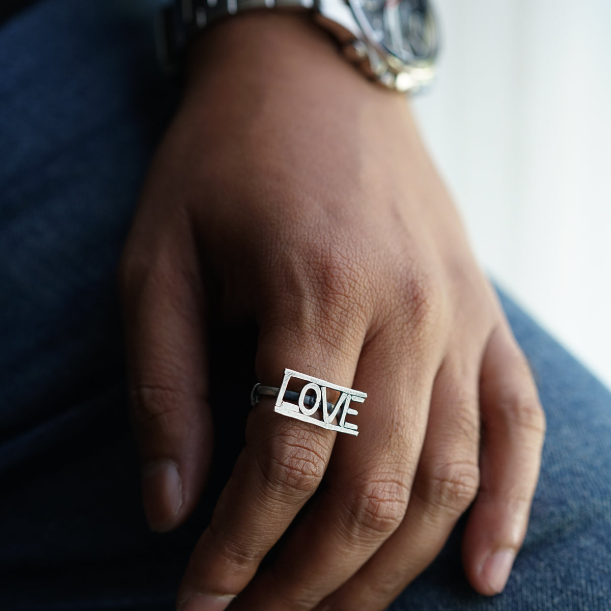 a person wearing a ring with the word love on it