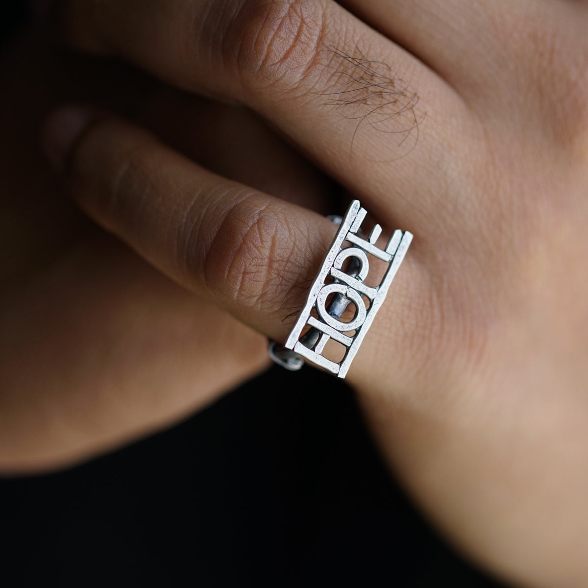 a close up of a person's hand with a ring on it