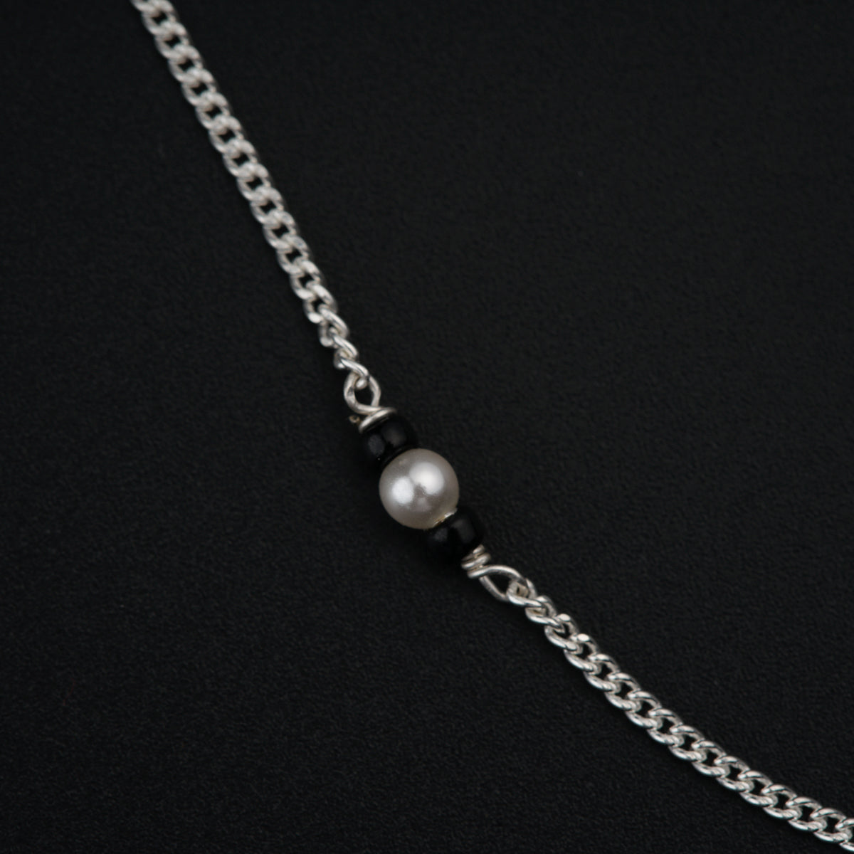 a black and white necklace with a pearl on it