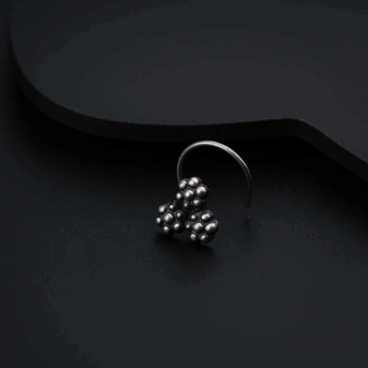 a close up of a metal object on a black surface