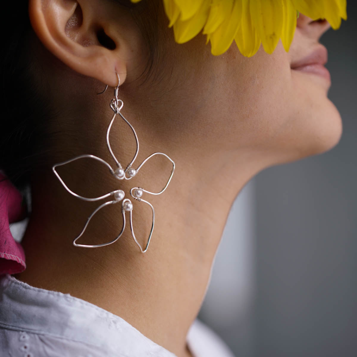 a close up of a person with a flower in their ear