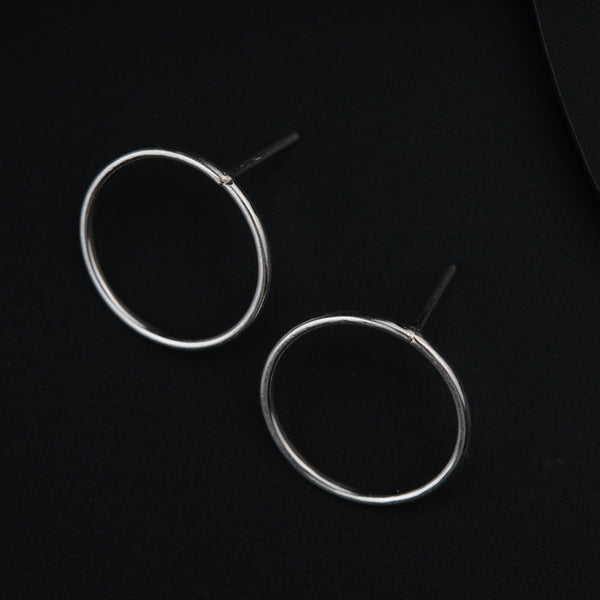 a pair of silver hoop earrings on a black background