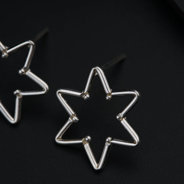 a pair of star shaped earrings on a black surface