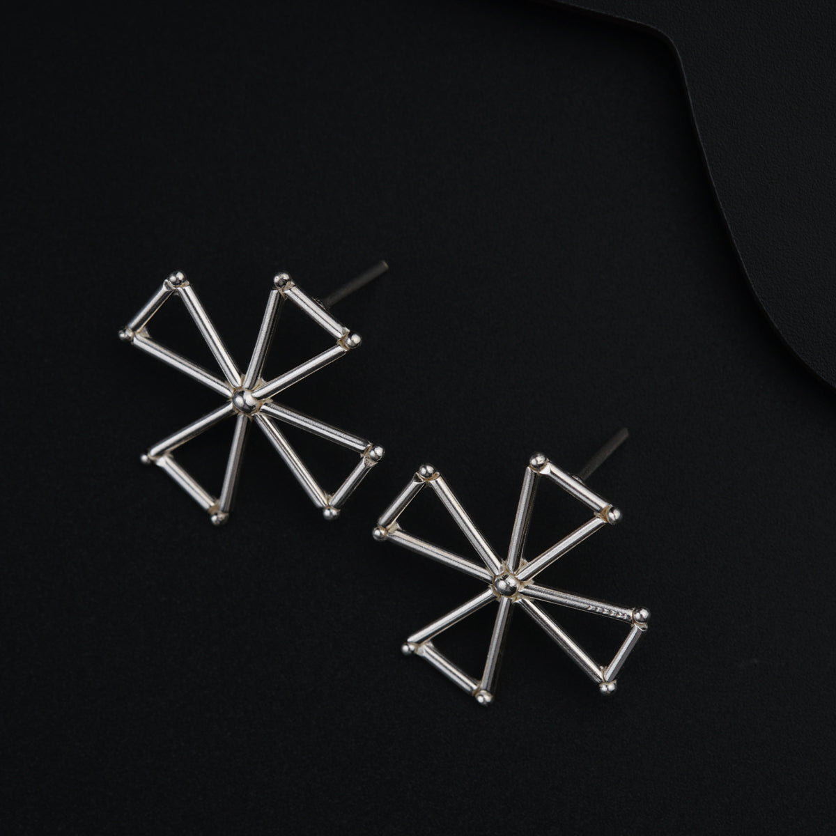 a pair of earrings on a black surface