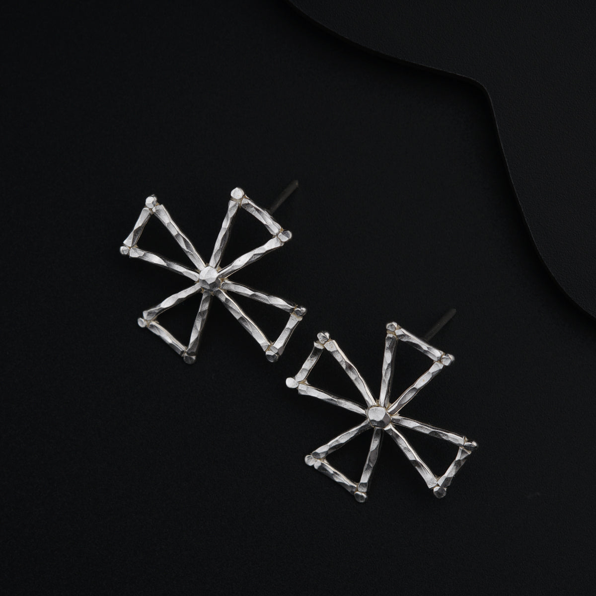 a pair of earrings on a black surface
