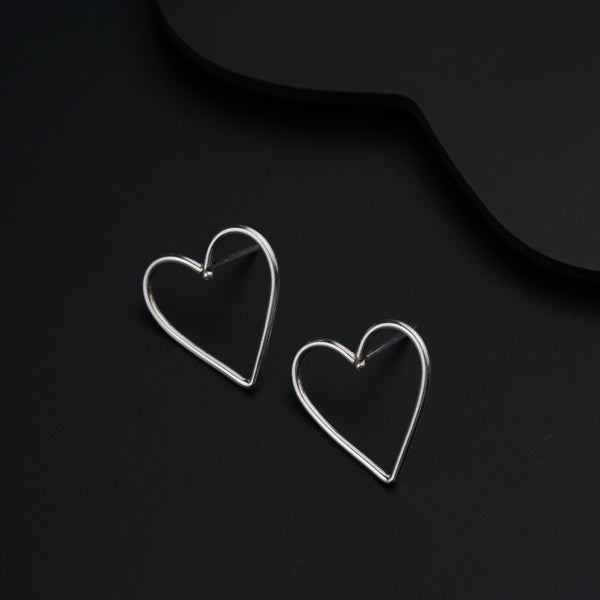 a pair of heart shaped earrings sitting on top of a table