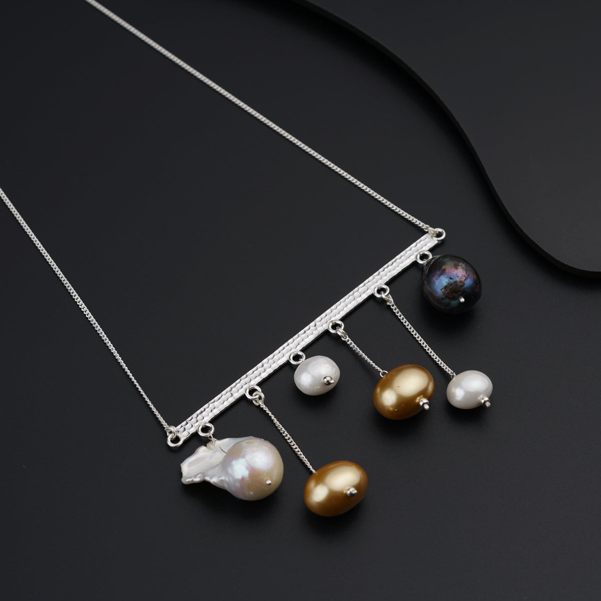 a necklace with five different pearls hanging from it
