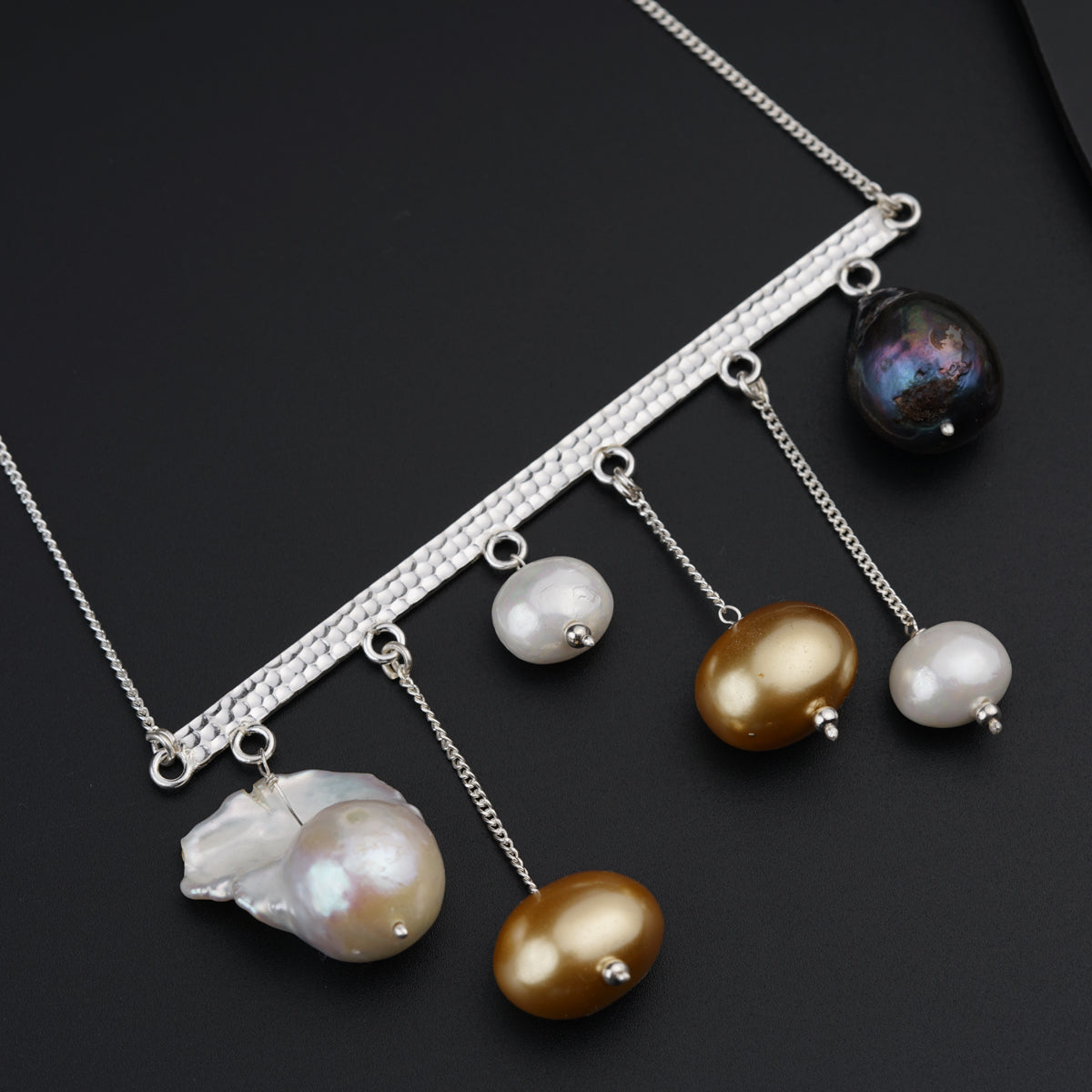 a close up of a necklace on a black surface