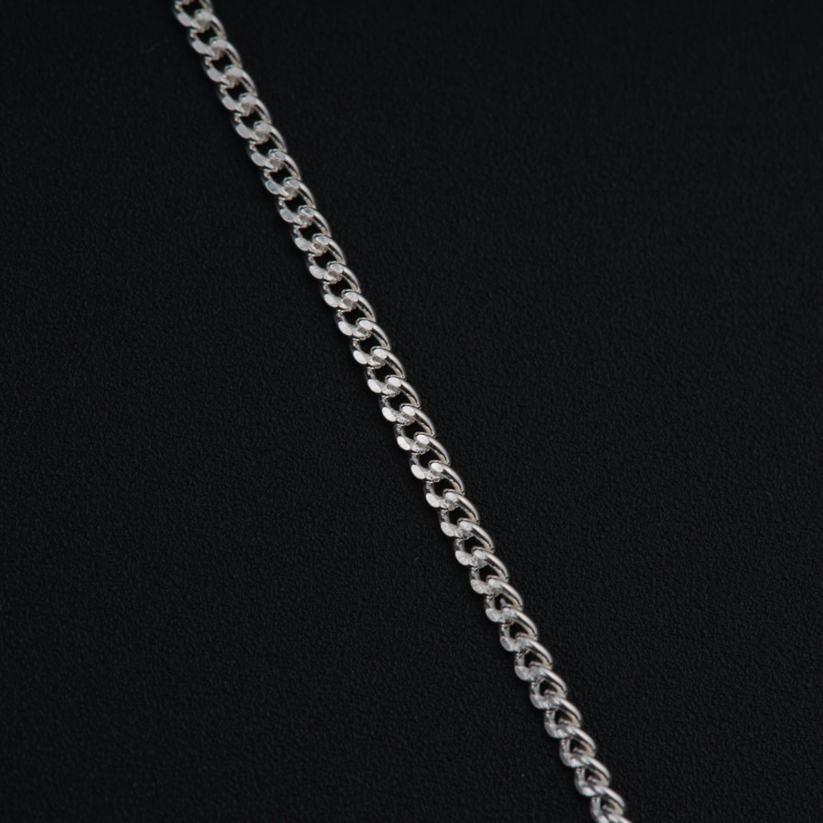 a close up of a chain on a black surface