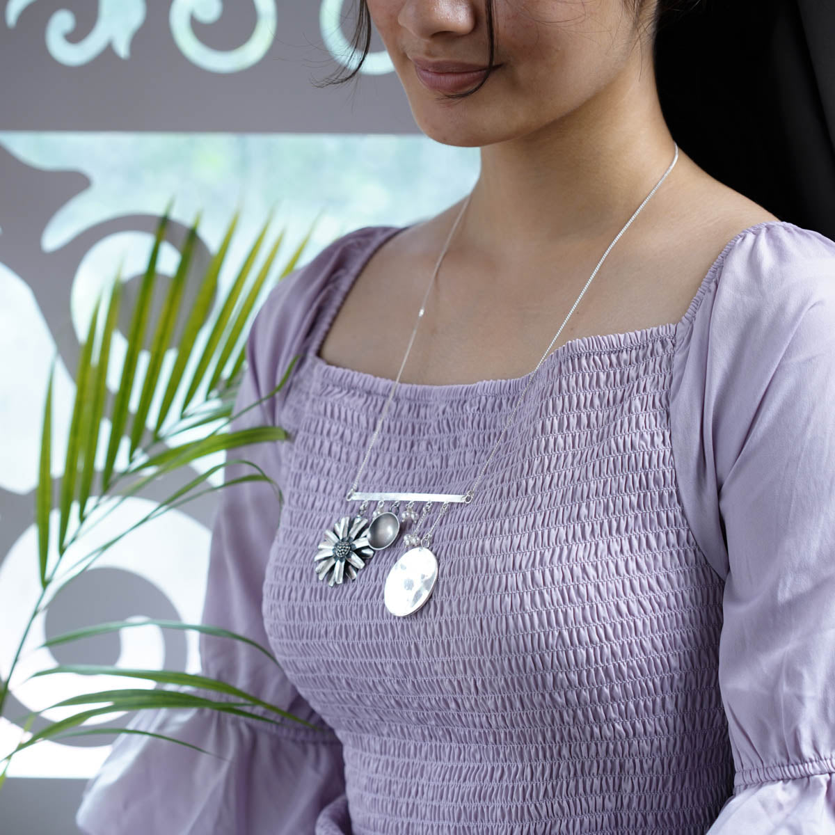 a woman in a purple dress holding a plant