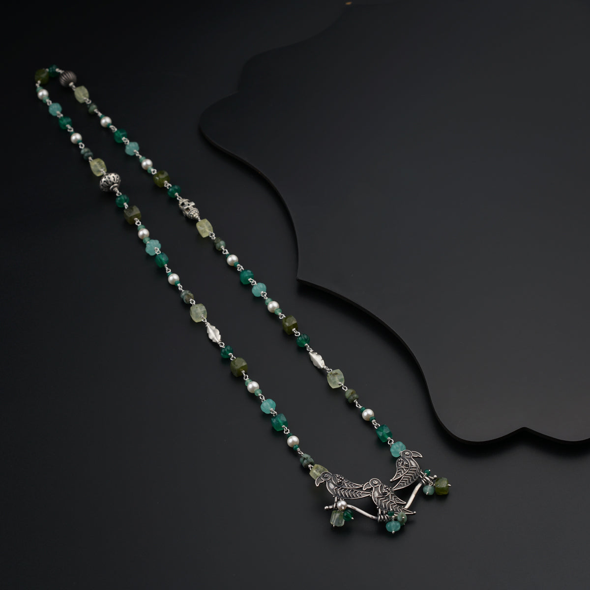 a long necklace with a bird on it